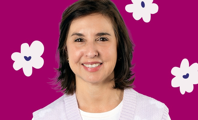Portrait of a woman smiling against a magenta background with floral accents.