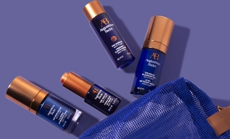  Assorted skincare products arranged with a blue cosmetic bag.