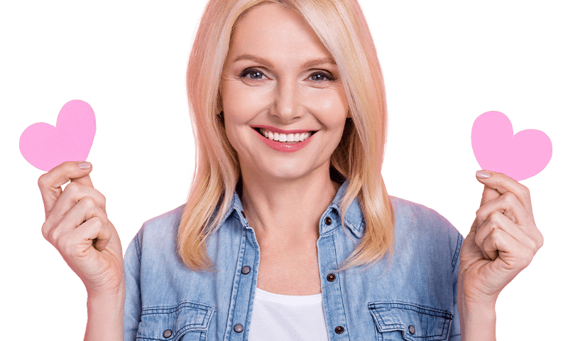 Smiling woman holding pink paper hearts on magenta background