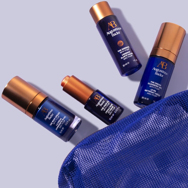 Assorted skincare products arranged with a blue cosmetic bag.