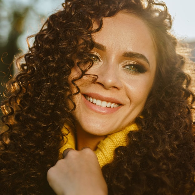 Woman smiling with the sun shining