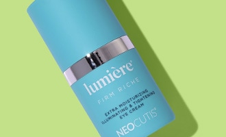 Blue skincare bottle displayed on a green background.