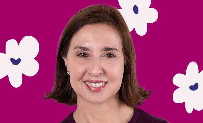 Portrait of a woman smiling against a magenta background with floral accents.