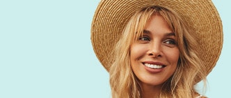 A smiling woman wearing a sun hat.