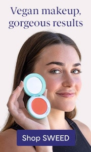 Young woman smiling and holding a blush compact