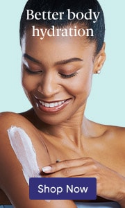 Woman smiling and applying lotion to her upper arm