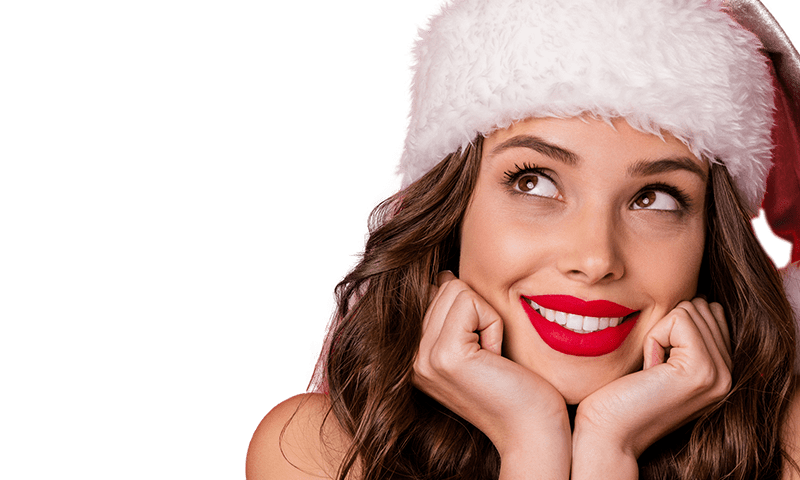 Woman in Santa hat with red lipstick smiling during the holidays