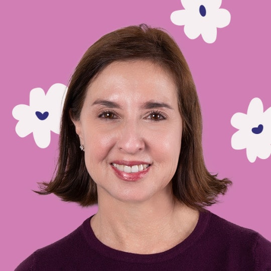 Portrait of a woman smiling against a magenta background with floral accents.