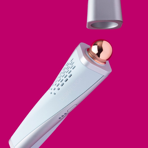 DERMAFLASH COOL Sonic Depuffing and Lymphatic Drainage tool, a pale blue and gray handheld skin care device with a polished rose gold spherical tip, against a bright magenta background.