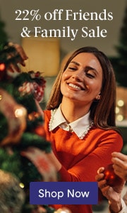 A brunette woman in a red sweater smiles while touching a Christmas tree, promoting a 22% off Friends & Family Sale.