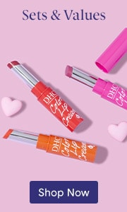 An orange, red and pink lip cream tube on a light pink background with two small pink hearts and a blue Shop Now button.