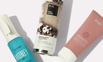 Assortment of hair care products from IGK, Color wow and Surface, on a neutral background.